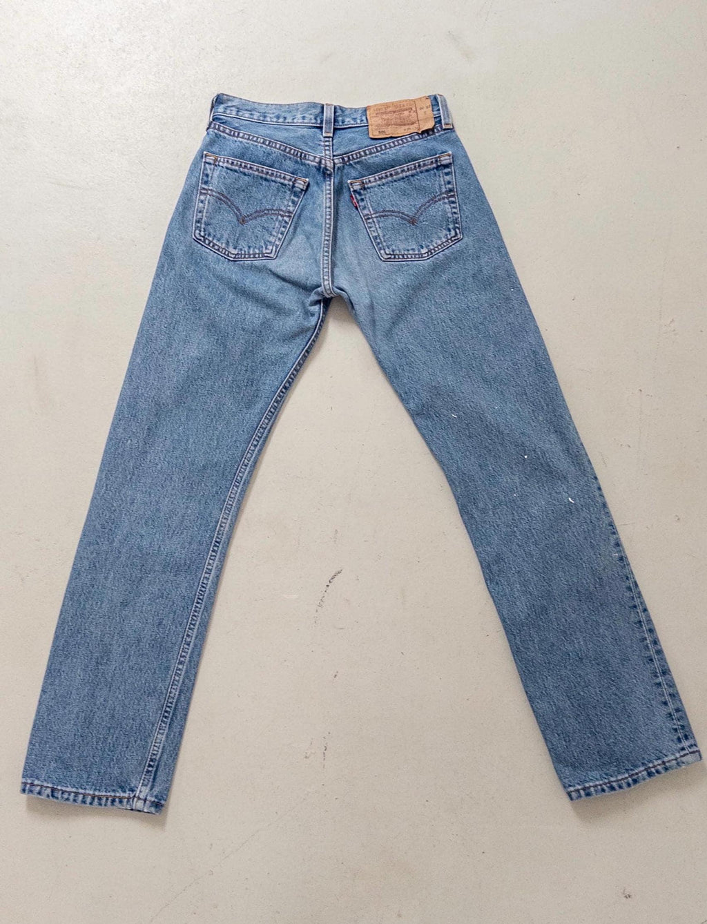 Gesamtansicht der Rückseite der flach ausgelegten Vintage Levis 501 Jeans (W26 L30) von girlstalkvintage, zeigt Schnitt, Taschenplatzierung und Waschung.
