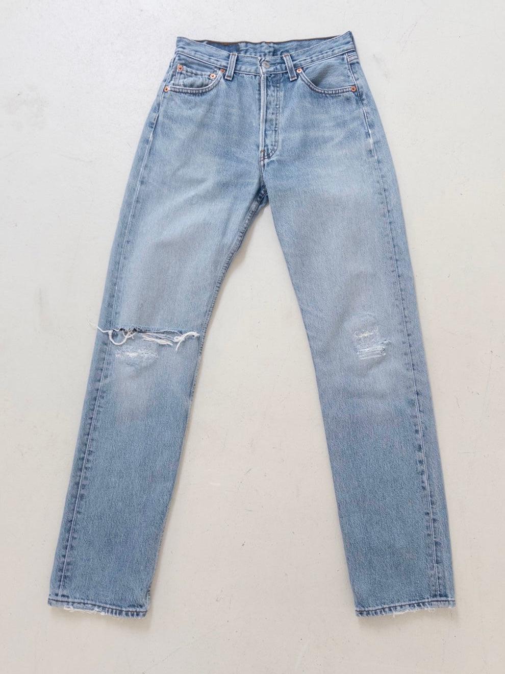 Flach liegend zu sehen ist die Levis 501 0114 Vintage Denim von 1998 Made in Poland Button Stamp 273 Button Fly / 4 Knöpfe Red Tab 100% Baumwolle in einem hellblauen, perfekt verwaschenem Look, sehr weich mit straight leg und zeitlos.