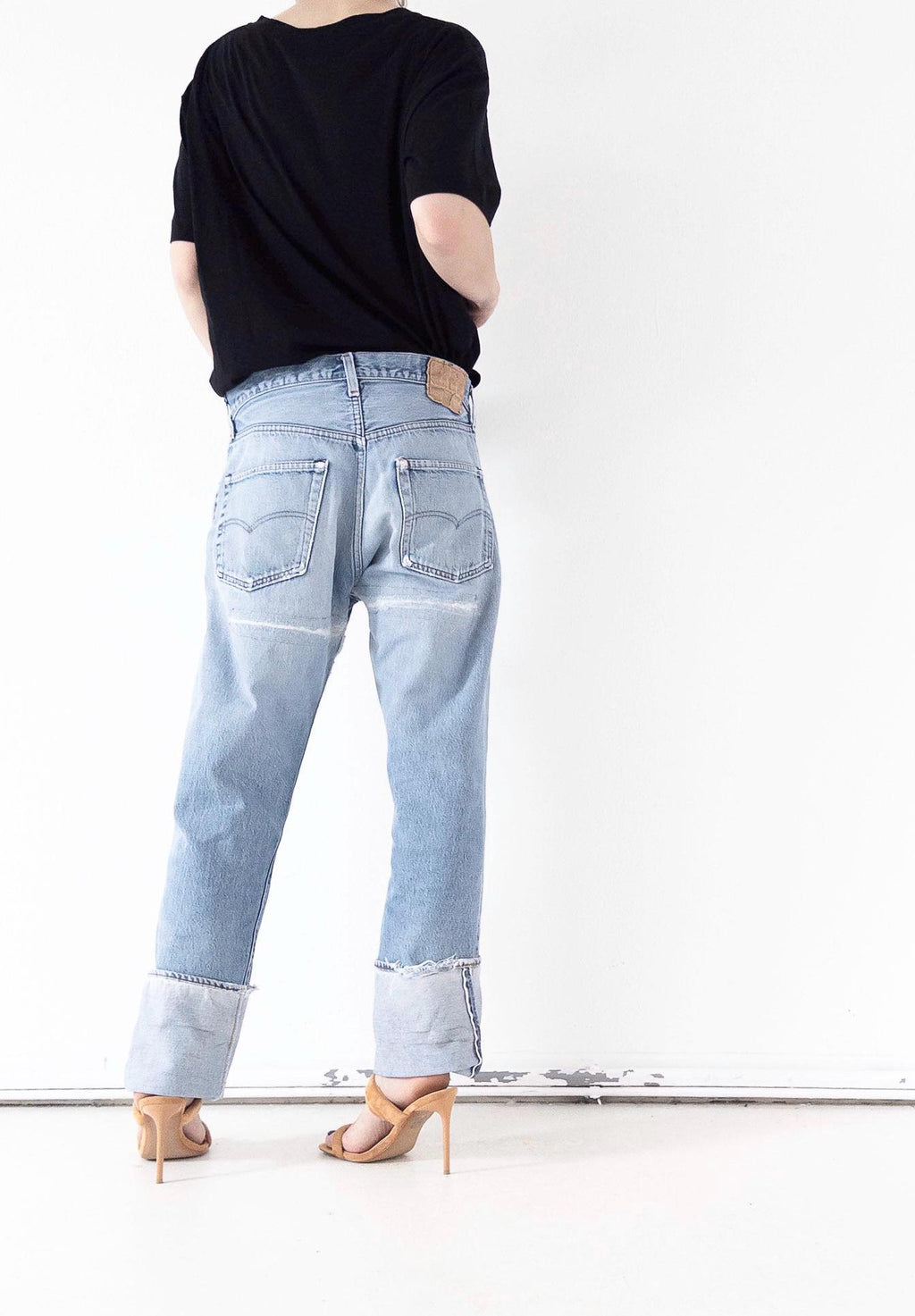 Rückansicht der hellblauen Vintage Levi’s 501 Selvedge Jeans im soft worn Grunge Distressed-Look mit geflicktem Po und Umschlag. One of a kind Unikat gestylt mit oversized Top und High Heels. Distressed Vintage Denim von girlstalkvintage.
