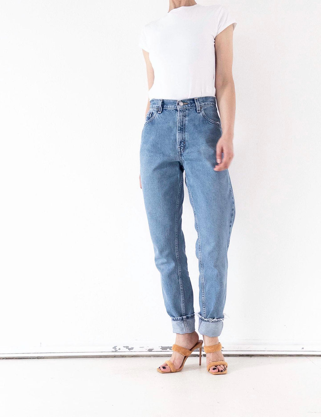 90s Vintage Levi's 550 Denim Jeans in Hellblau W26 L34 Tapered Fit High Rise, seitlich angewinkelt sieht man den Balloon Look und das Barrel Denim Leg.