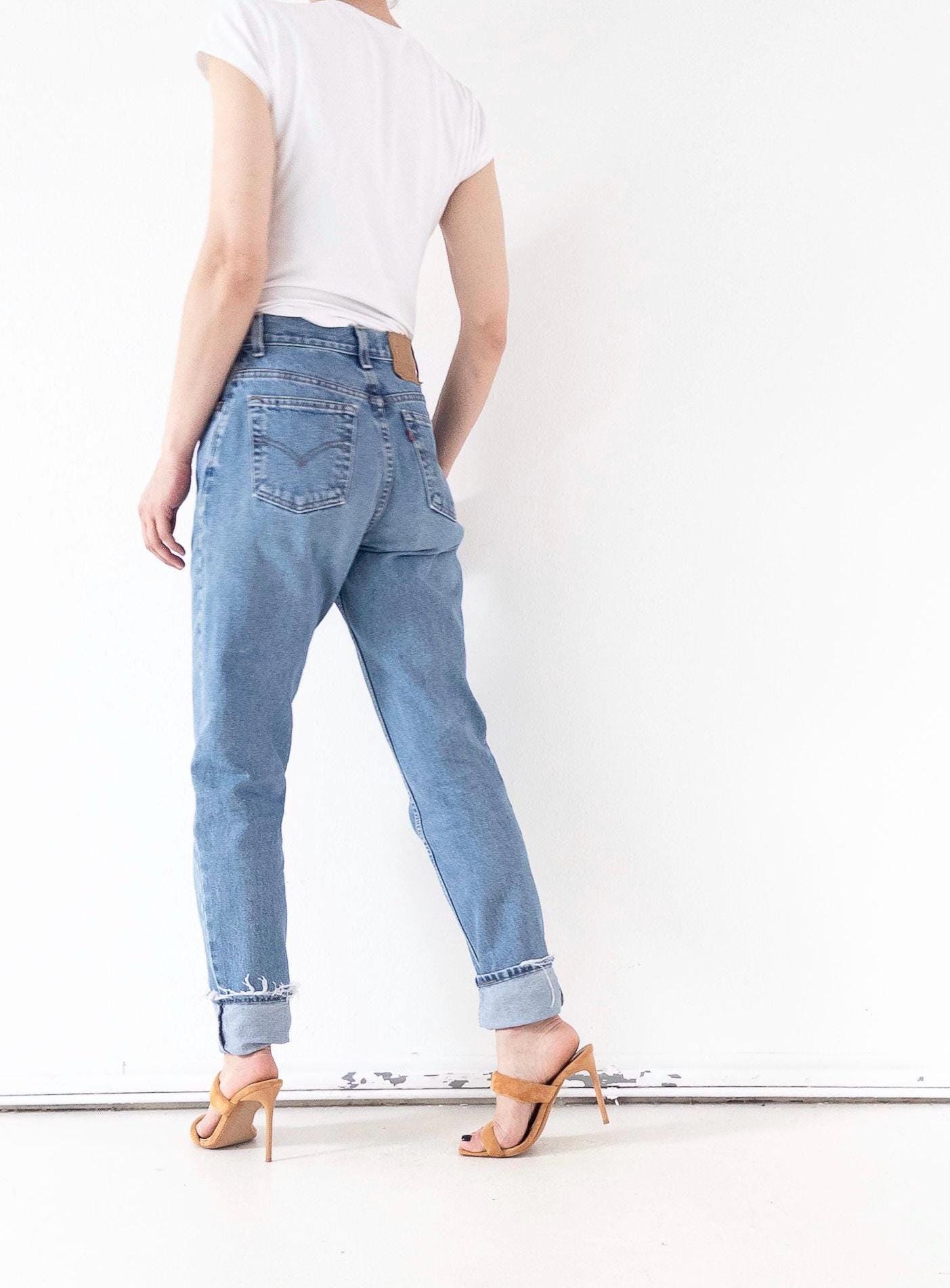 Seitenprofil Vintage Levi's 550 High Waist Jeans in W26 L34, die Passform an Po und Bein zeigt. Deutlich sichtbar: Eine Po-Tasche mit Arcuate-Naht und das ikonische Red Tab.