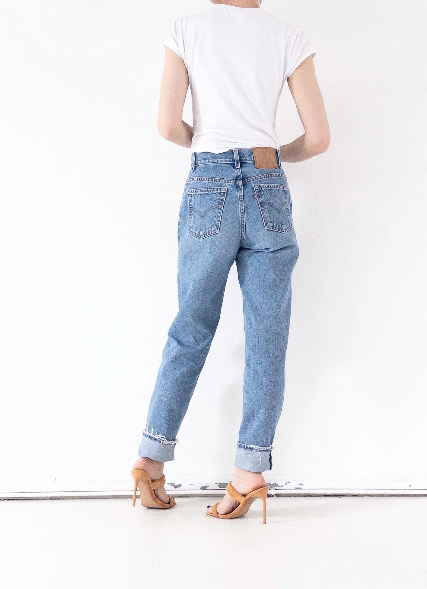 girlstalkvintage trägt Vintage 90s Levi's 550 Mom Jeans, Ansicht von hinten, kombiniert mit weißem T-Shirt und Absätzen. Perfekte Passform am Po.
