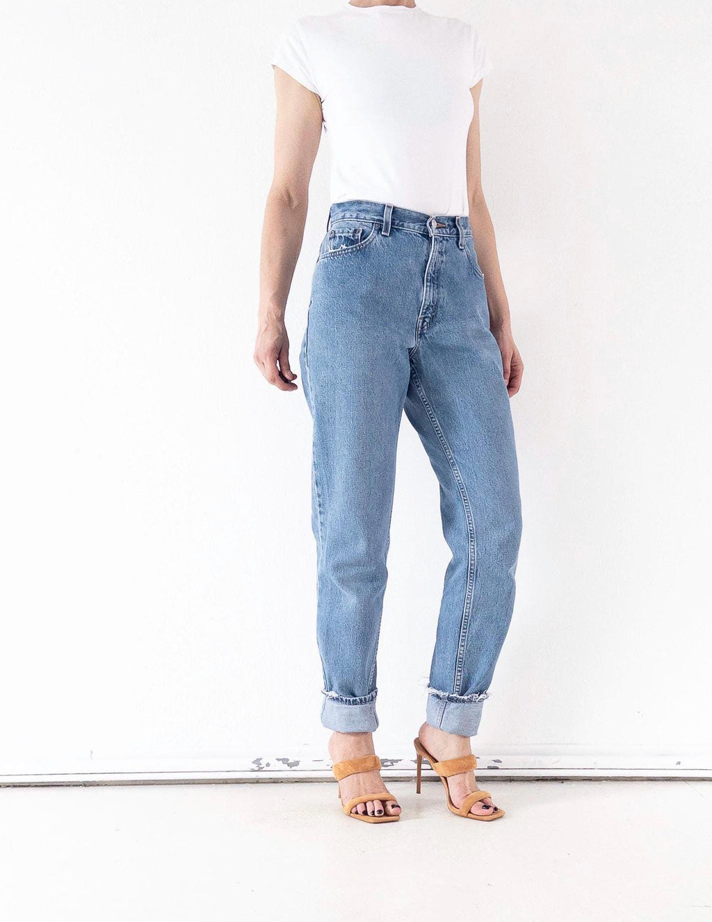 Vorderansicht Vintage Levis 550 High Waist Jeans W26 L34. Zeigt den Bund, die vorderen Taschen & den Tapered-Schnitt, gestylt mit T-Shirt & Mules