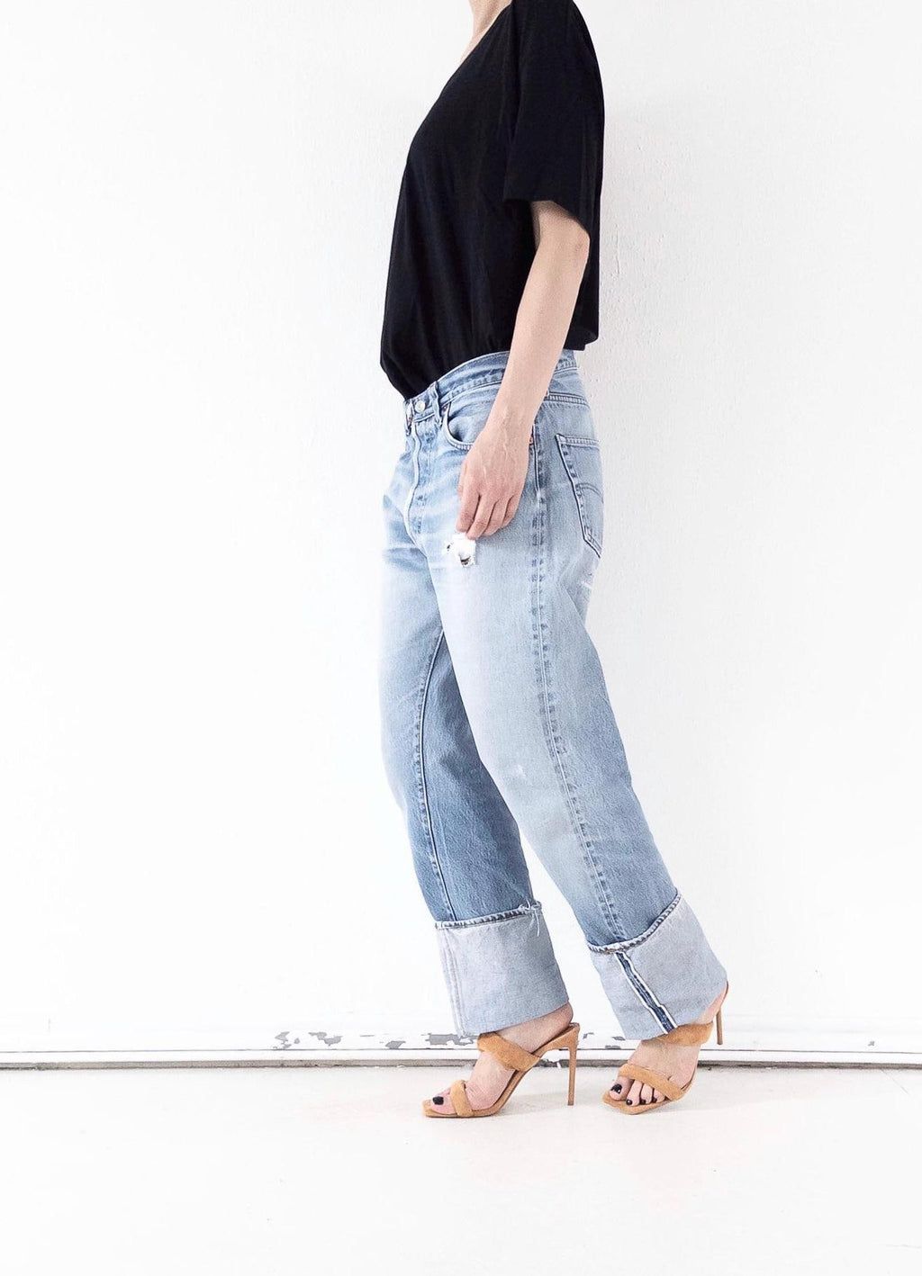 Faded Light Blue Levi’s 501 Selvedge Jeans seitlich in Bewegung. Vintage One of a Kind Piece, made in USA,  mit soft worn used-Waschung, Grunge Distressed-Details und markanter Webkante am gekrempeltem Saum.