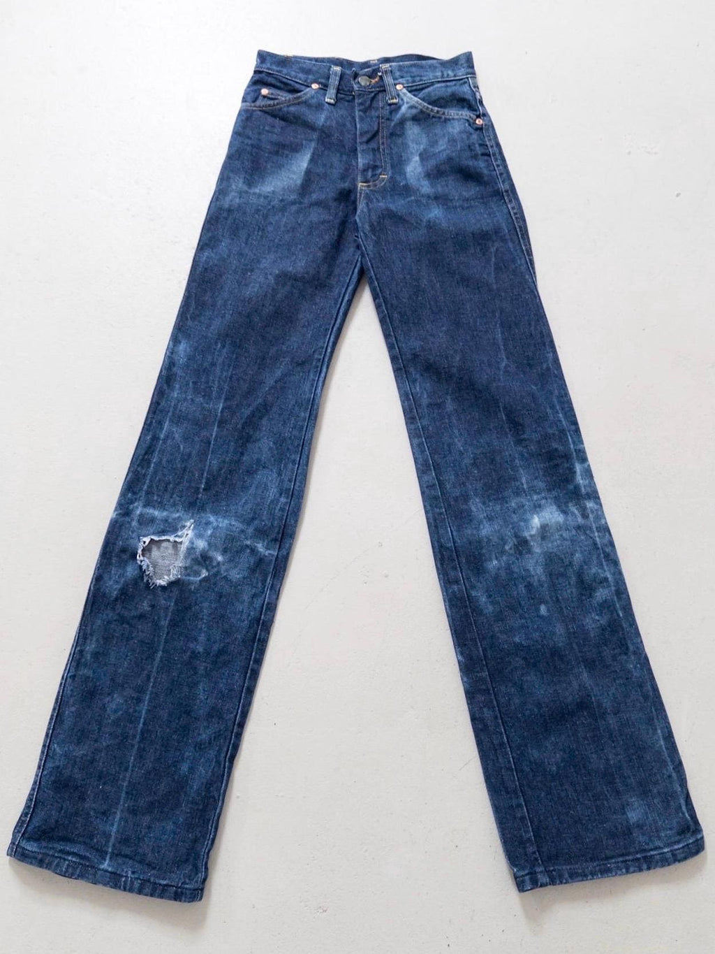 Flatlay 70s Vintage Lee Flared Jeans Dunkelblau mit extremem Schlag & Sun Faded Effekt und Thrashed Details am Knie.