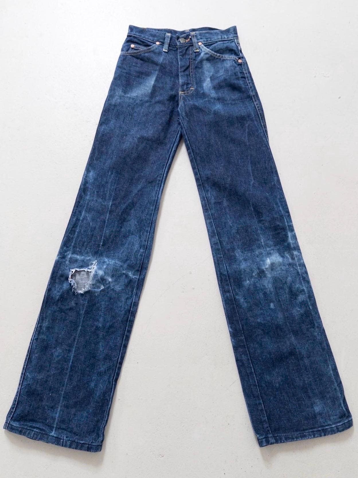 Flatlay 70s Vintage Lee Flared Jeans Dunkelblau mit extremem Schlag & Sun Faded Effekt und Thrashed Details am Knie.