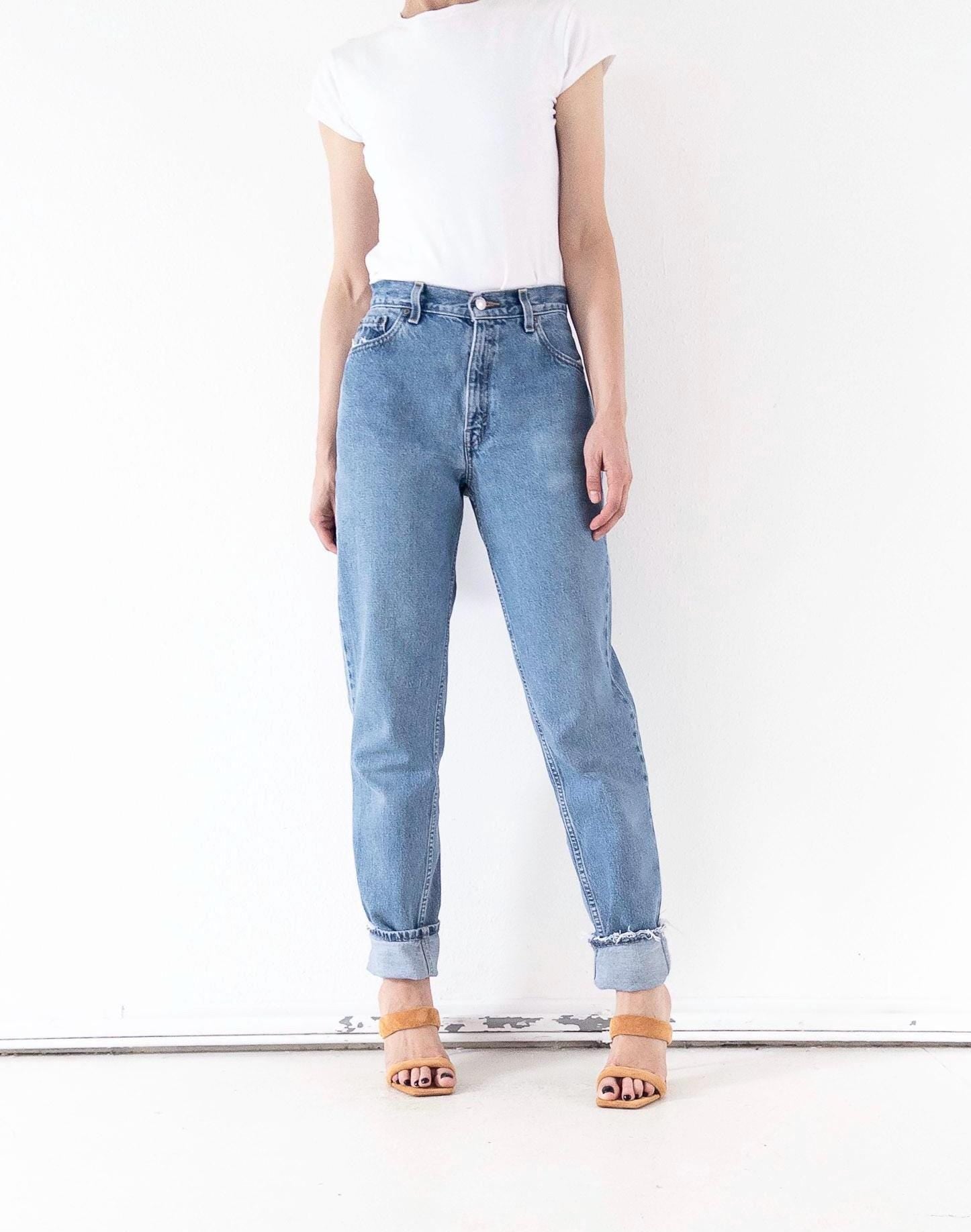 Vintage Levi's 550 High Waist Jeans W26 L34 in Hellblau, gestylt mit weißem T-Shirt und Pantoletten bei girlstalkvintage