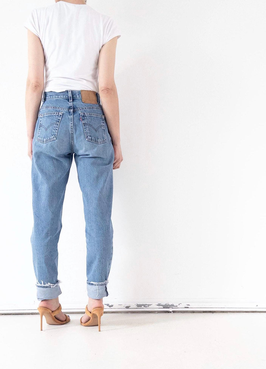 Rückansicht der Vintage Levi's 550 High Waist Jeans in W26 L34, die Passform an Po und Bein zeigt. Deutlich sichtbar: Eine Po-Tasche mit Arcuate-Naht und das ikonische Red Tab.